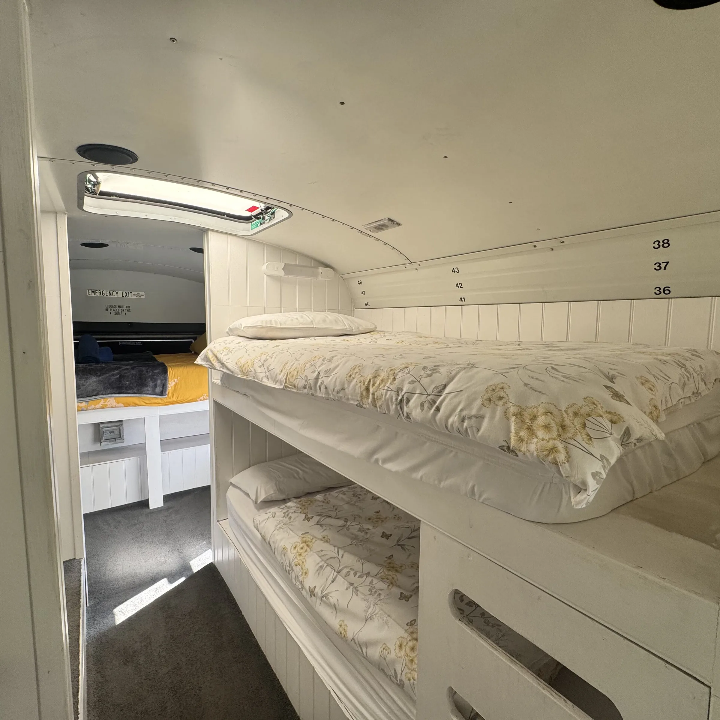 The set of bunks inside Bluebird, made up with floral bedding