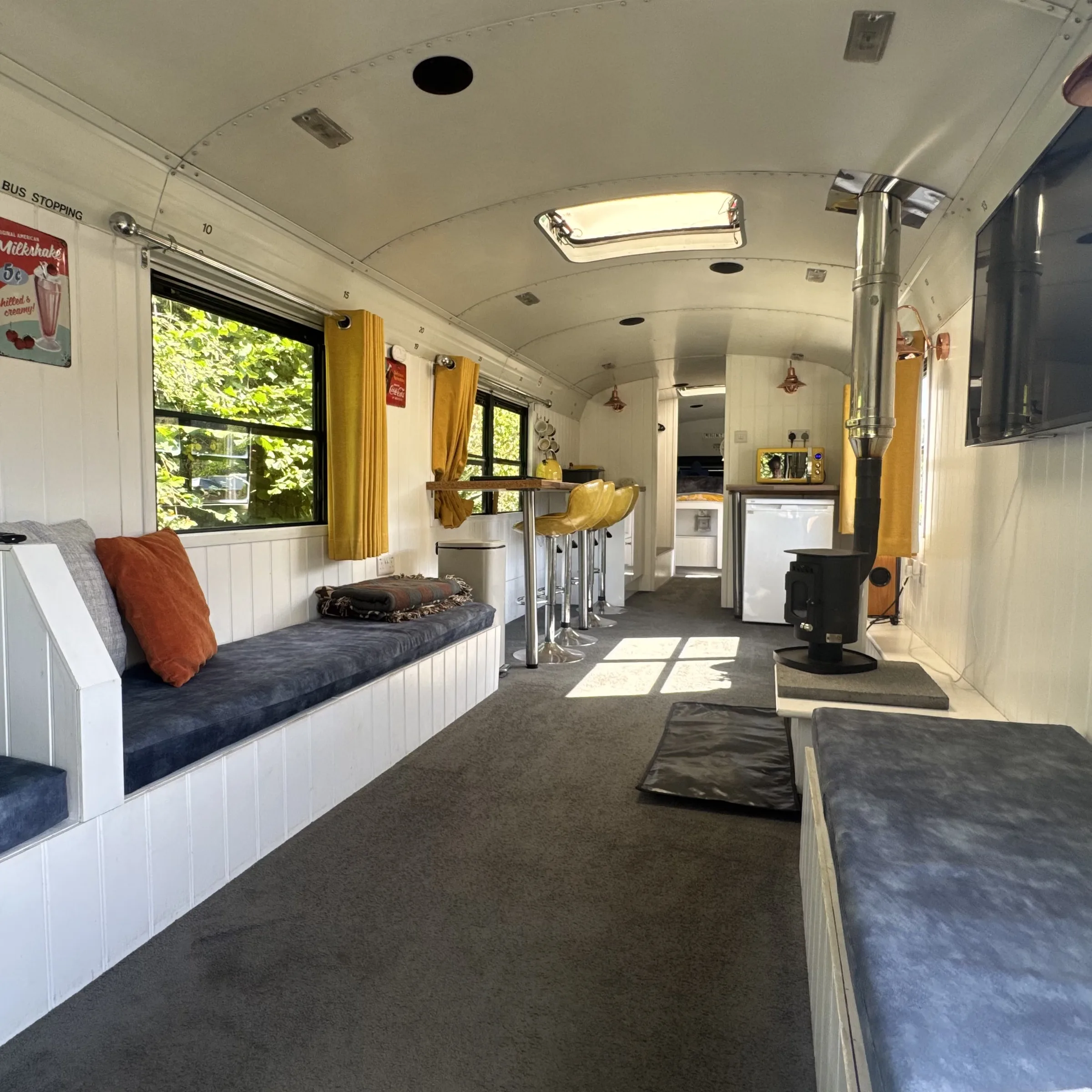 Looking the full length of the bus, past the seating and breakfast bar to the kitchen at the far end