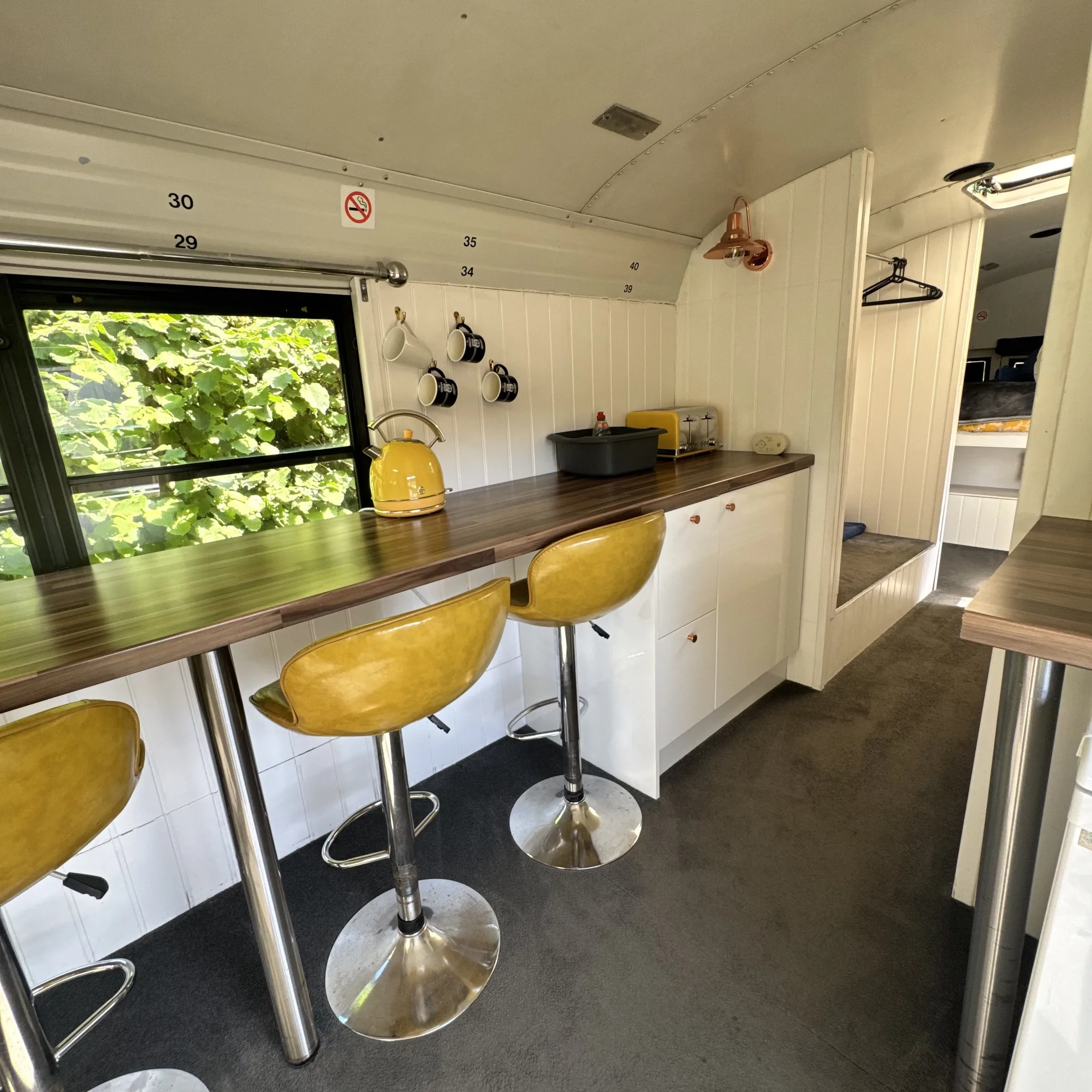 The kitchen run inside Bluebird, with worktop, storage drawers and mugs hung on the wall