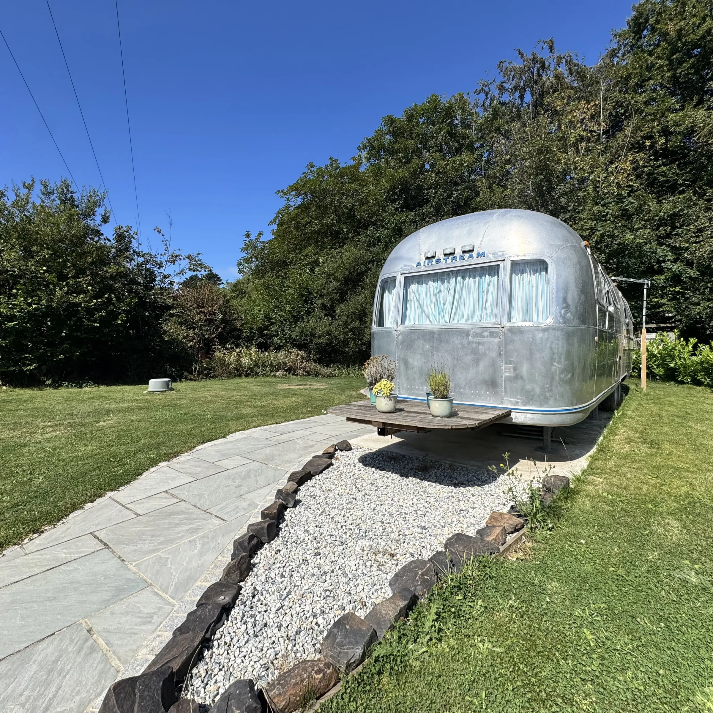 The path leading up to Boskenna’s Airstream, with potted plants set out on the deck