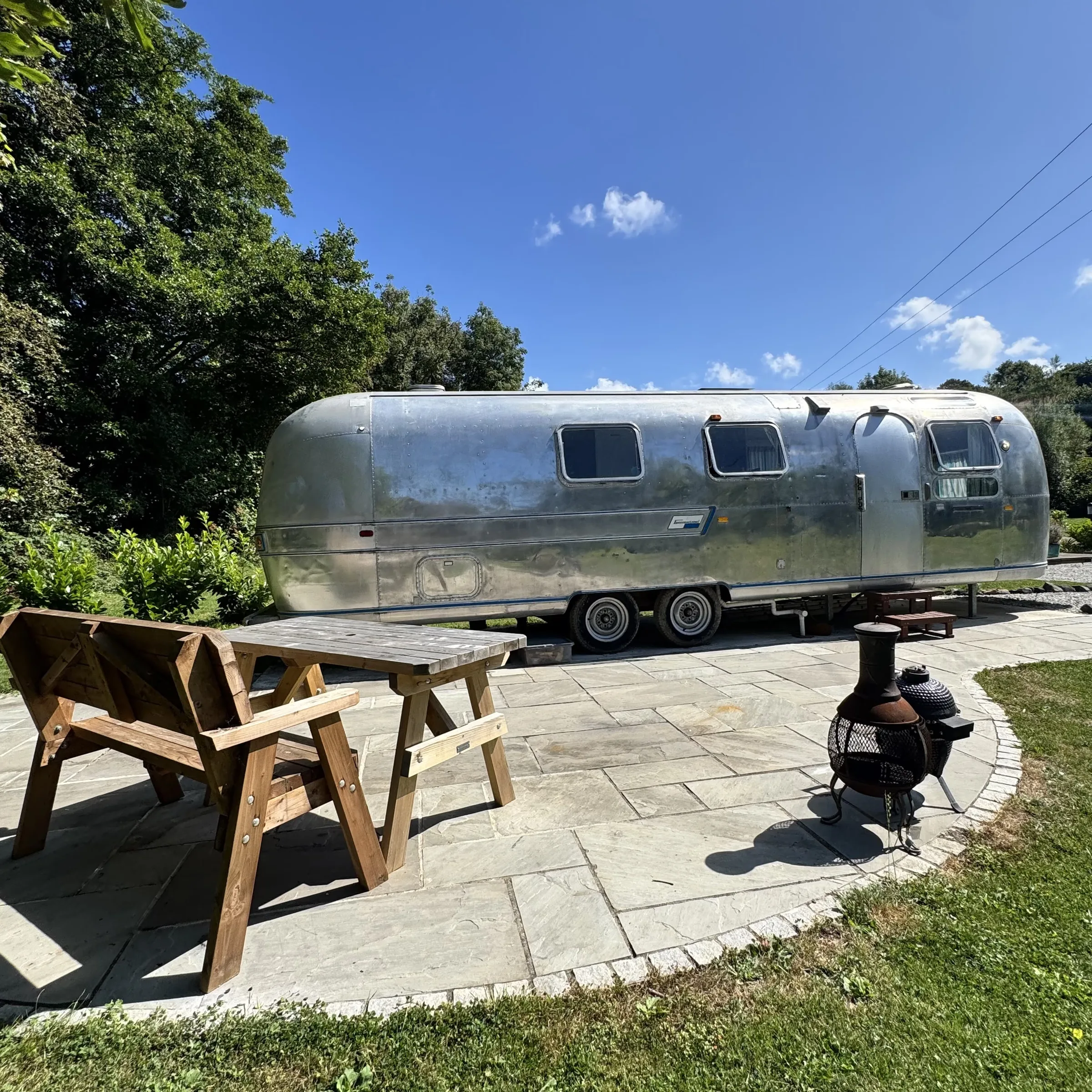 The picnic bench and chiminea beside the Airstream at Boskenna