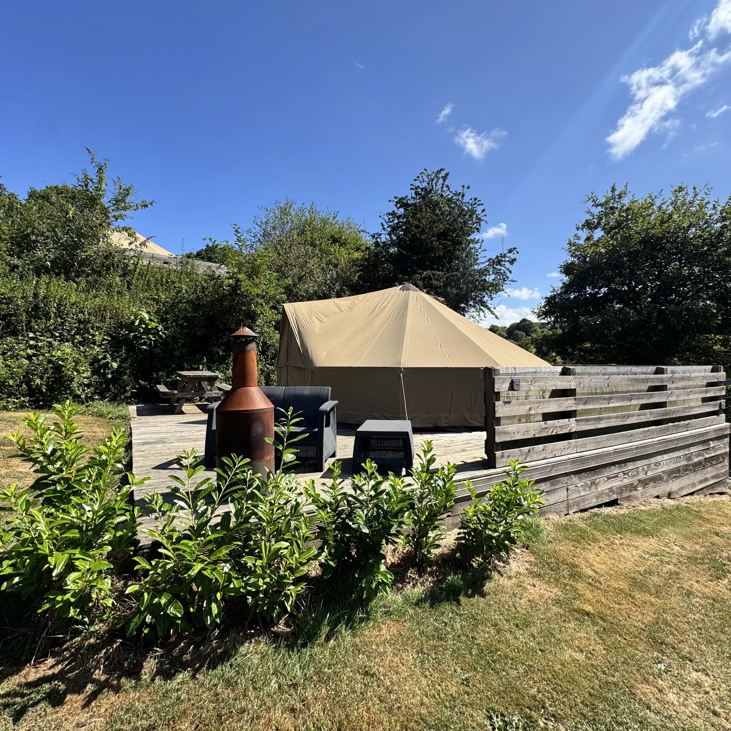 The rattan sofa and chiminea on Hartland’s deck, with the picnic bench beyond