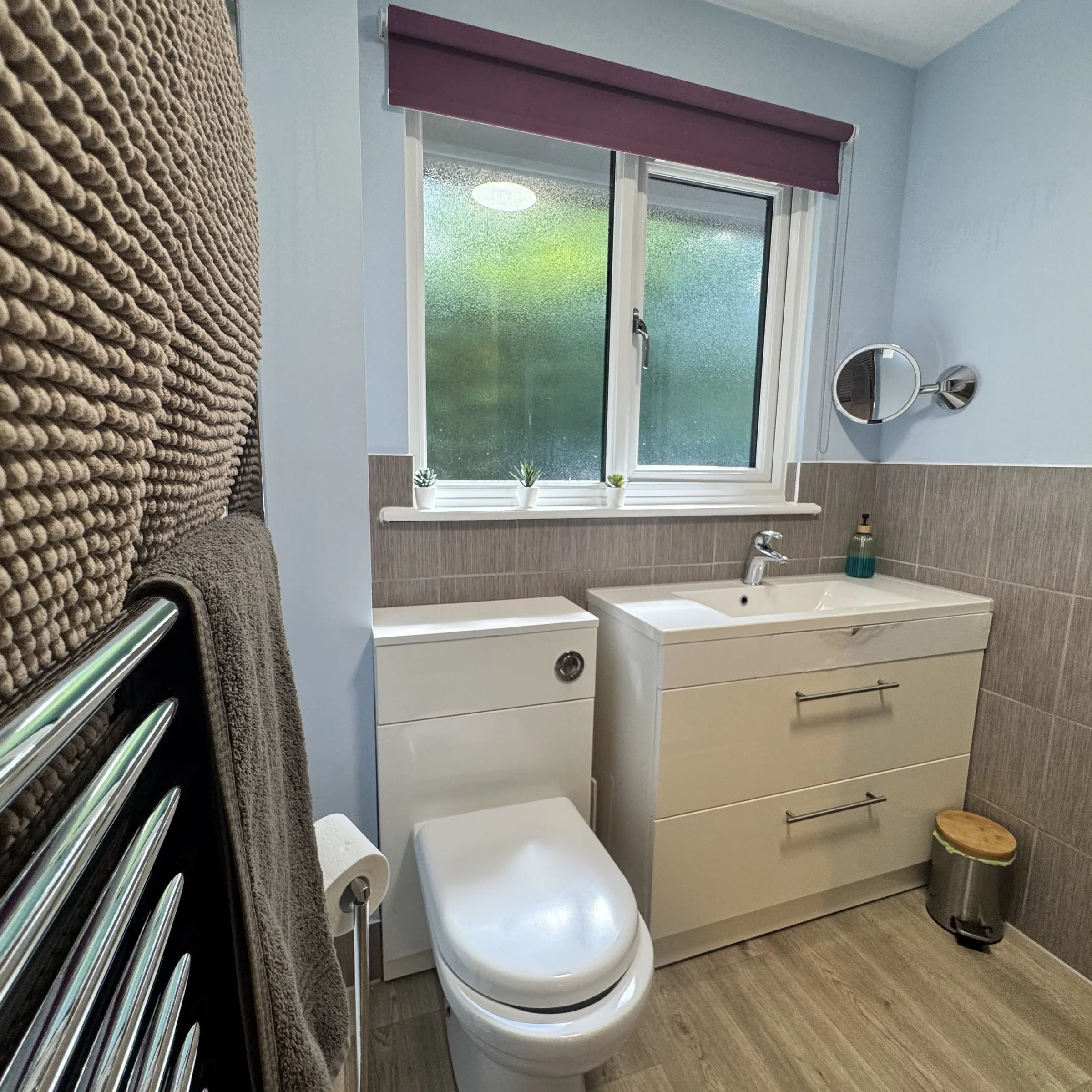The bathroom at Heath, with basin, WC and a heated towel rail hung with towels