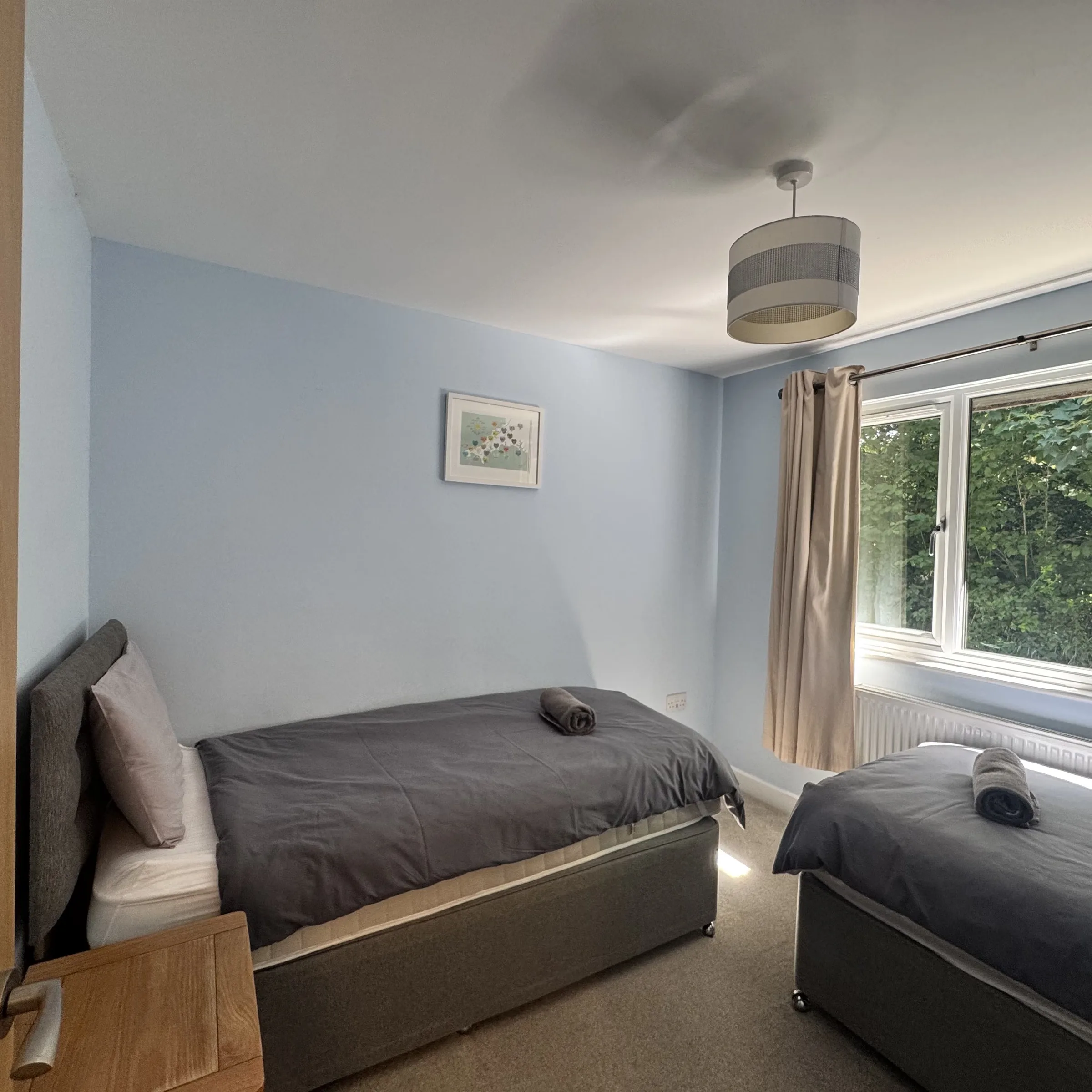 The twin bedroom at Heath, with both beds made up and artwork above