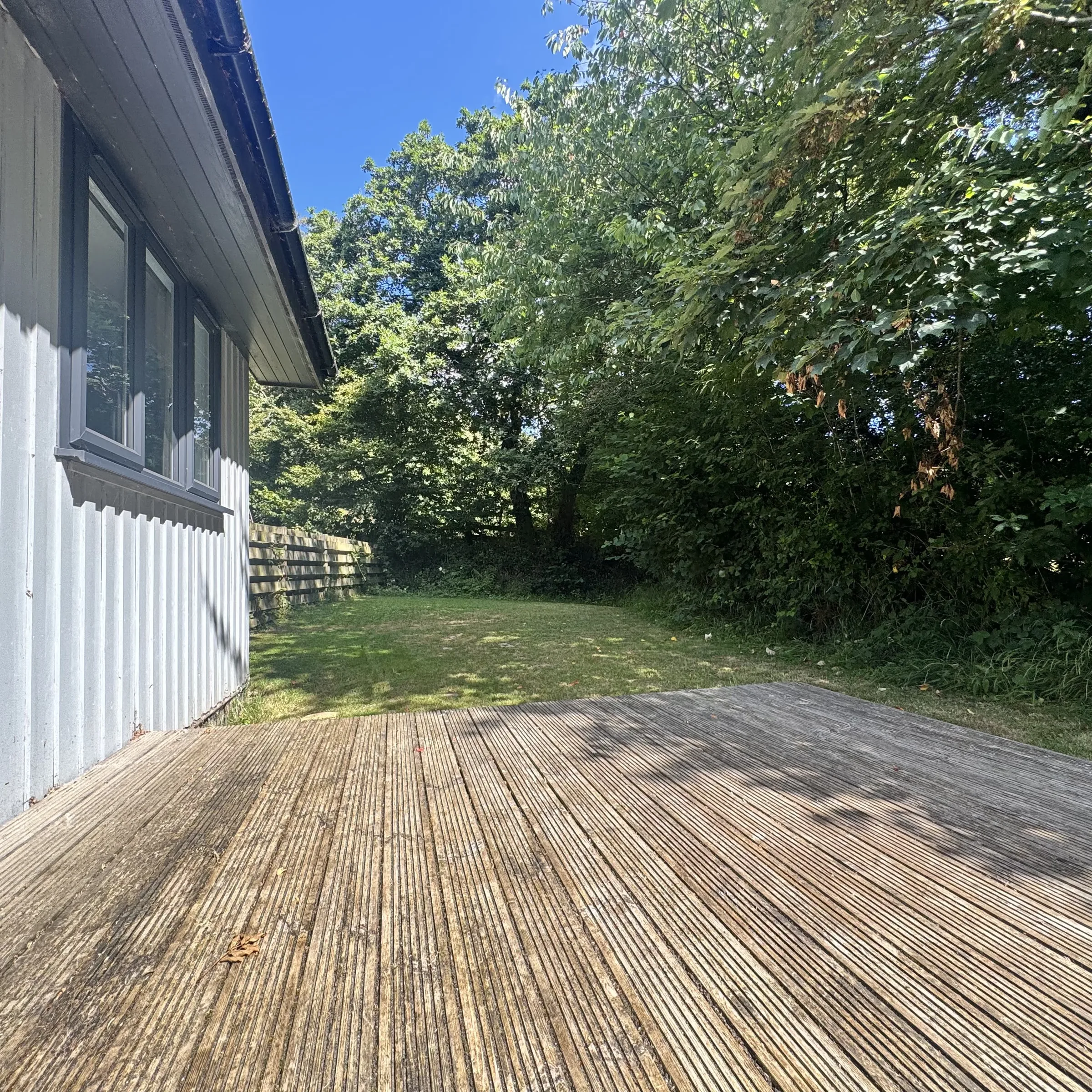 The decking at the back of Heath, opening onto the lawn and mature trees