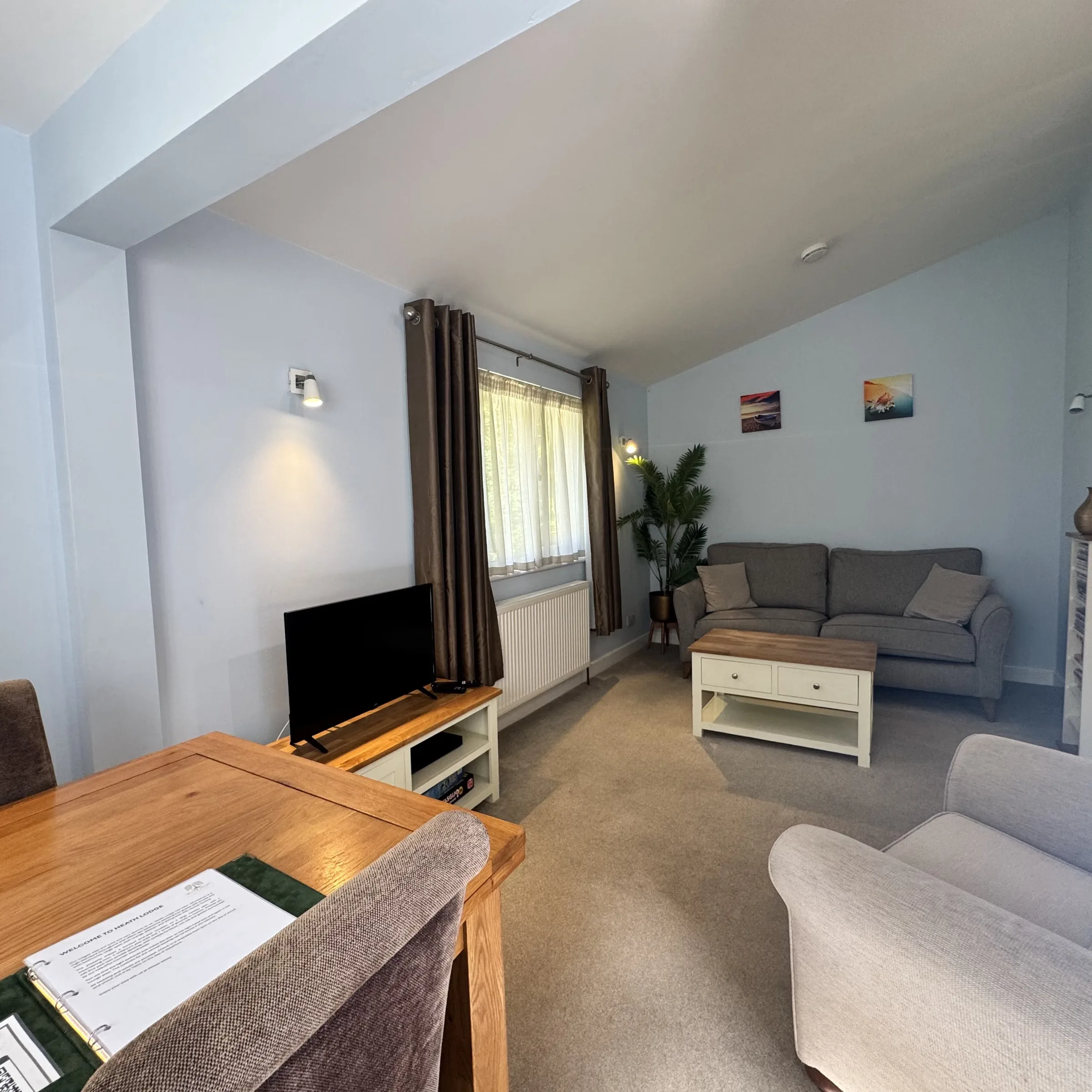 The open-plan living space at Heath, with sofas, the TV and the dining table beyond