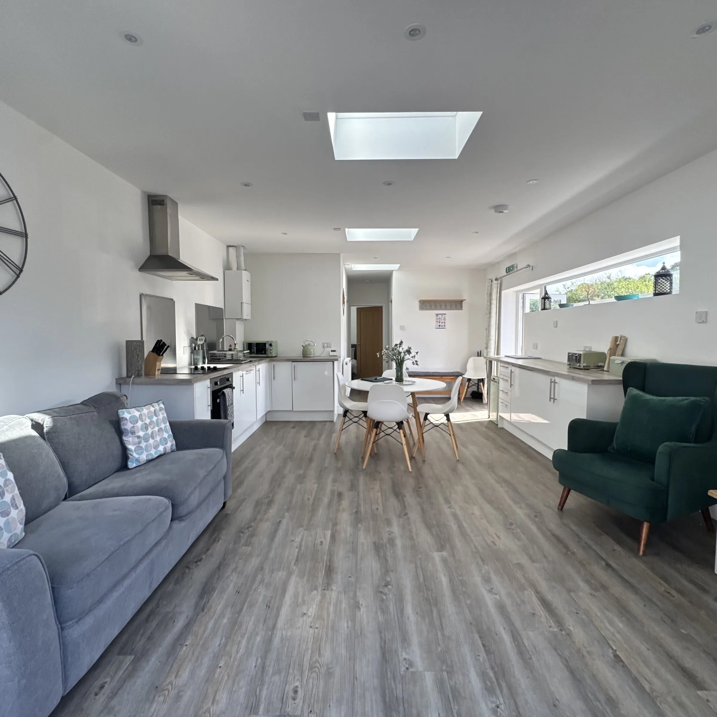 The open-plan kitchen and lounge-diner at Helyk, with skylights over the middle of the room and the window looking out to the patio