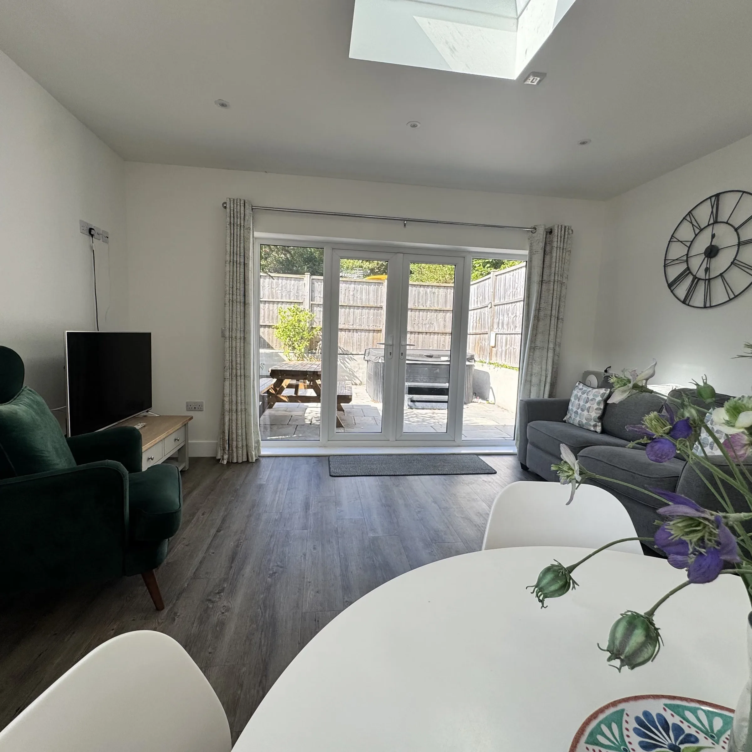 The lounge at Helyk, with sofa, armchair and TV beside the patio doors