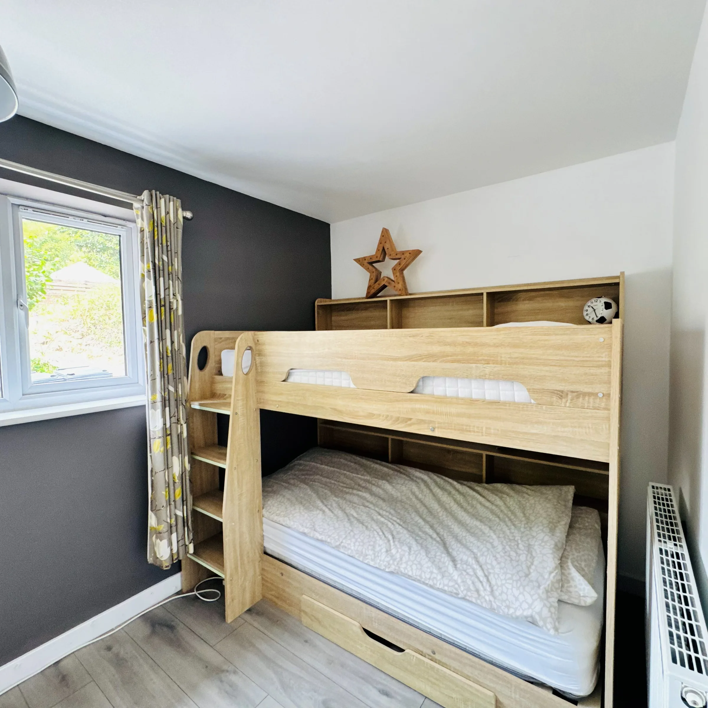 A Mordros bunk room with a built-in wooden bunk bed and a star ornament on the shelf above