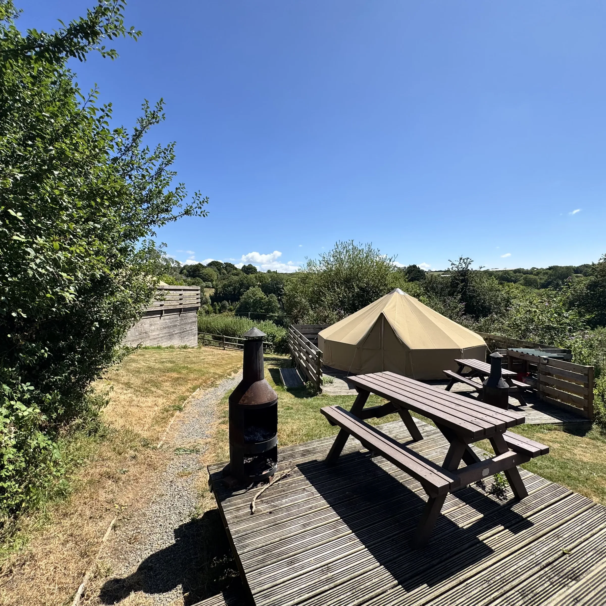 The picnic table and chiminea on Sea Campion’s deck, with the valley view beyond